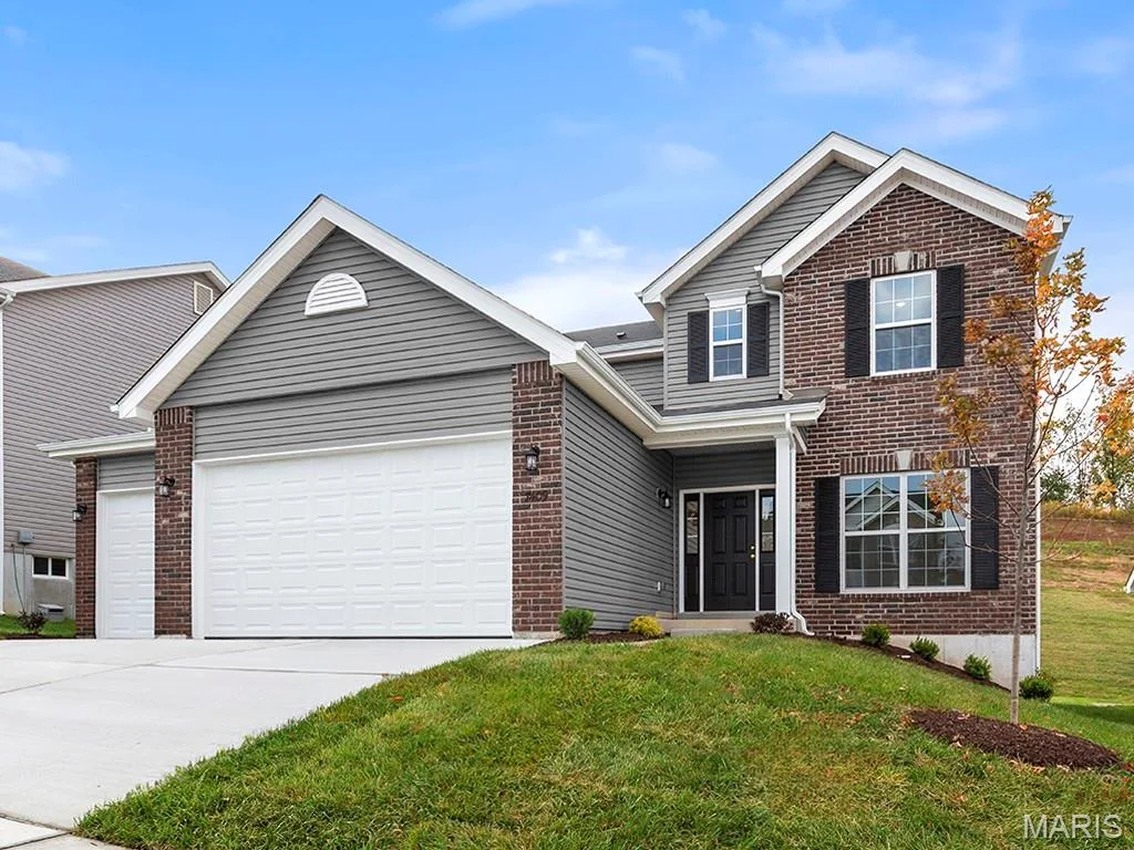 Traditional home with brick siding, driveway, a garage, and a front lawn — 225 Windmill View Drive, O'Fallon, MO 63385