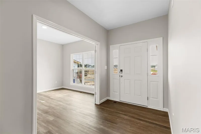 Entrance foyer featuring dark wood-style flooring and baseboards — 225 Windmill View Drive, O'Fallon, MO 63385