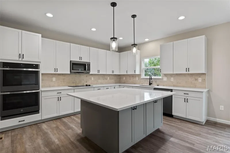 Kitchen featuring white cabinets, pendant lighting, appliances with stainless steel finishes, and recessed lighting — 225 Windmill View Drive, O'Fallon, MO 63385