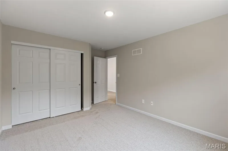 Unfurnished bedroom featuring light colored carpet and a closet — 225 Windmill View Drive, O'Fallon, MO 63385