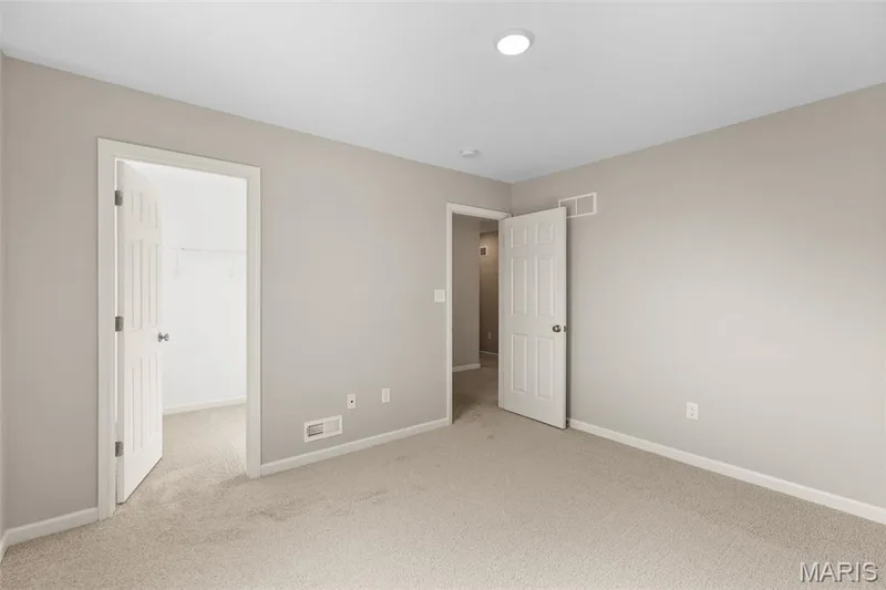 Unfurnished bedroom featuring light colored carpet and a spacious closet — 225 Windmill View Drive, O'Fallon, MO 63385