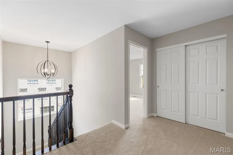 Hall featuring an upstairs landing, a chandelier, and light colored carpet — 225 Windmill View Drive, O'Fallon, MO 63385