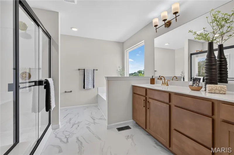 Primary bathroom with tub and cultured marble 12 inch seat in shower and double wave bowl vanity. — 431 Oak Barrel Drive, O'Fallon, MO 63385