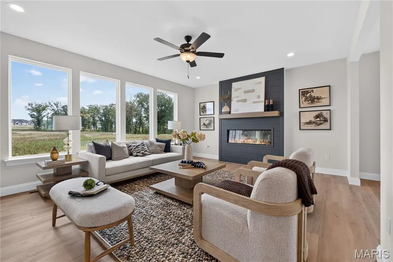 Family room with view of window wall, fireplace and ceiling fan — 431 Oak Barrel Drive, O'Fallon, MO 63385