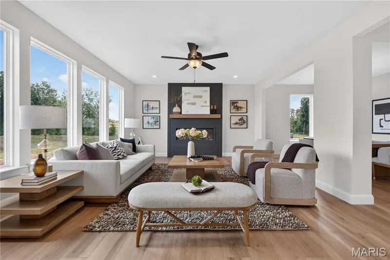 Family room with view of window wall and ceiling fan — 431 Oak Barrel Drive, O'Fallon, MO 63385