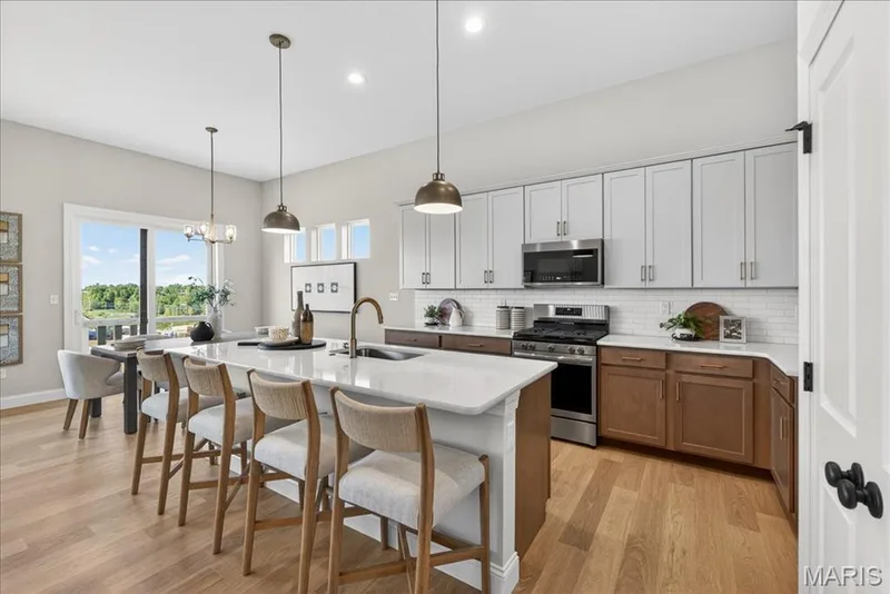 Kitchen with custom cabinets, Quartz countertops and stainless steel gas appliances — 421 Farmhouse Drive, O'Fallon, MO 63385