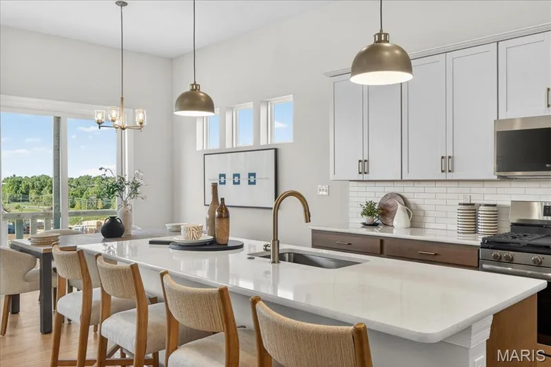 Kitchen with custom cabinets, Quartz countertops and stainless steel gas appliances — 421 Farmhouse Drive, O'Fallon, MO 63385