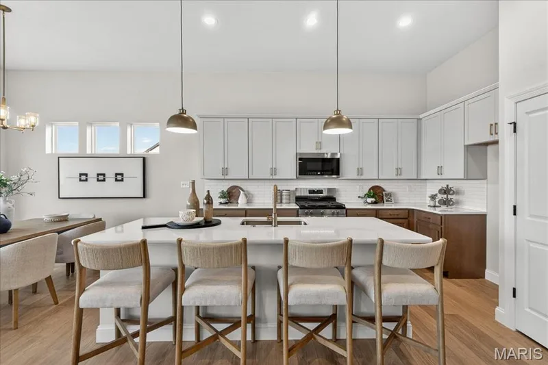 Kitchen with custom cabinets, Quartz countertops and stainless steel gas appliances — 421 Farmhouse Drive, O'Fallon, MO 63385