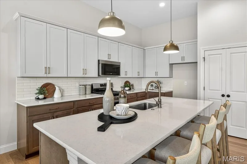 Kitchen with custom cabinets, Quartz countertops and stainless steel gas appliances — 421 Farmhouse Drive, O'Fallon, MO 63385