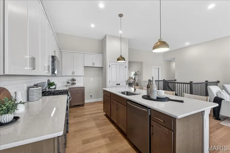 Kitchen with custom cabinets, Quartz countertops and stainless steel gas appliances — 421 Farmhouse Drive, O'Fallon, MO 63385