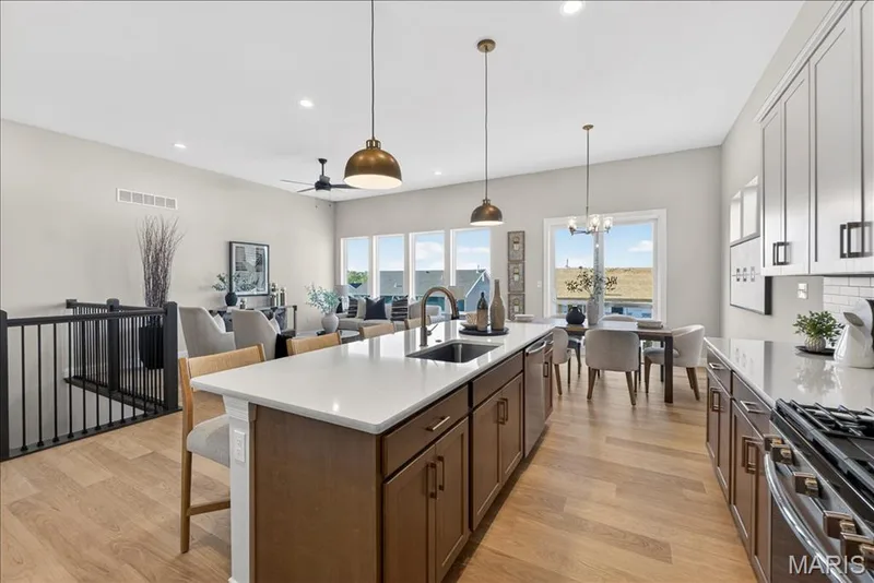 Kitchen with custom cabinets, Quartz countertops and stainless steel gas appliances — 421 Farmhouse Drive, O'Fallon, MO 63385