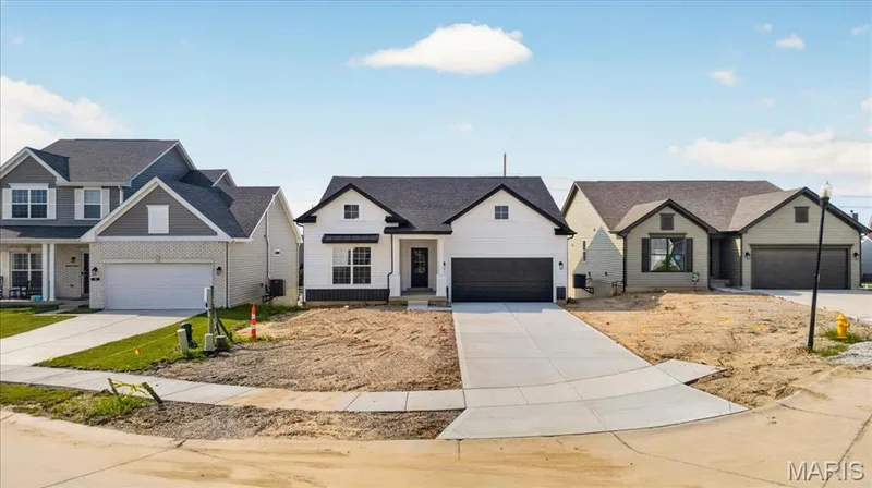 This beautifully designed home showcases timeless architecture with contrasting black and white finishes, front gables, elegant columns, and a spacious covered entry. Thoughtfully designed to offer exceptional curb appeal that stands out. — 86 River Wind Drive, St Charles, MO 63301
