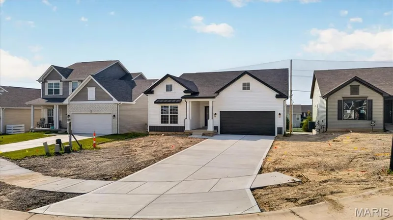 Enjoy contemporary curb appeal with this stylish exterior featuring durable horizontal siding, dramatic black trim, charming front porch, and an oversized garage. A perfect blend of classic character and modern design. — 86 River Wind Drive, St Charles, MO 63301