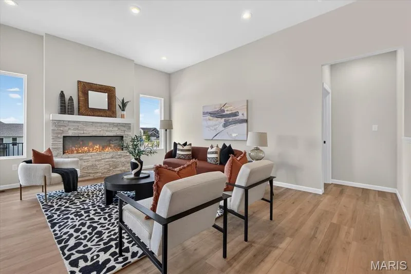 Designed for everyday living and effortless entertaining, the open-concept great room offers impressive ceiling heights, abundant natural light, luxury flooring, and a beautiful stone fireplace as its centerpiece. — 86 River Wind Drive, St Charles, MO 63301