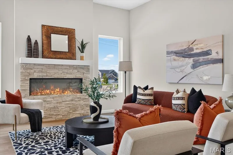 Enjoy an airy, light-filled great room with 11' ceilings, oversized windows, and a striking stone fireplace that creates a warm and inviting atmosphere. The open design flows naturally into the dining area, making gatherings a breeze. — 86 River Wind Drive, St Charles, MO 63301