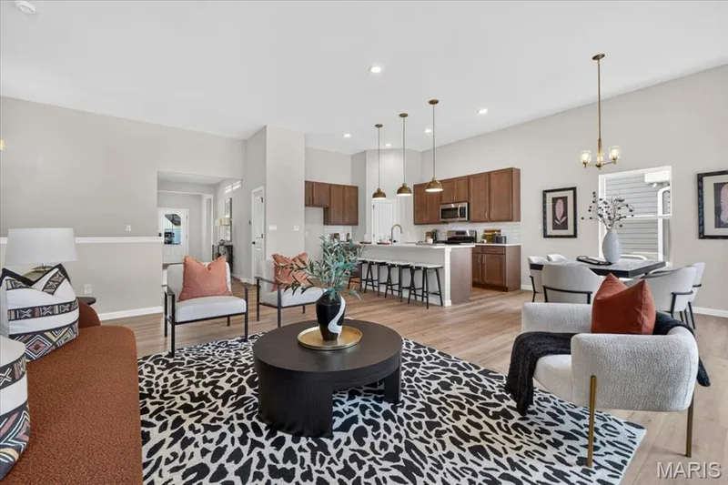 The impressive great room combines timeless design with modern comfort, featuring soaring ceilings, a dramatic stone fireplace, expansive windows, and an open-concept layout that creates the perfect space for relaxing or entertaining guests. — 86 River Wind Drive, St Charles, MO 63301