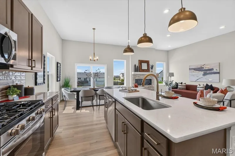 The heart of the home, this beautifully designed kitchen features a large center island with seating, quartz countertops, abundant cabinetry, stainless steel appliances, and an open layout that flows effortlessly into the dining area and great room. — 86 River Wind Drive, St Charles, MO 63301