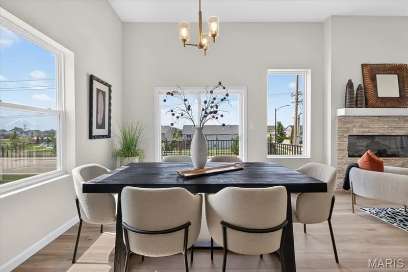The bright breakfast area offers the perfect place to start your day, with abundant natural light, soaring ceilings, and easy access to the covered deck for seamless indoor-outdoor dining. — 86 River Wind Drive, St Charles, MO 63301