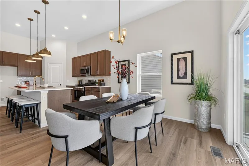 Designed with both comfort and functionality in mind, the breakfast area offers an inviting dining space with vaulted ceilings, beautiful natural light, and direct access to the covered deck, perfect for morning coffee or evening meals outdoors. — 86 River Wind Drive, St Charles, MO 63301