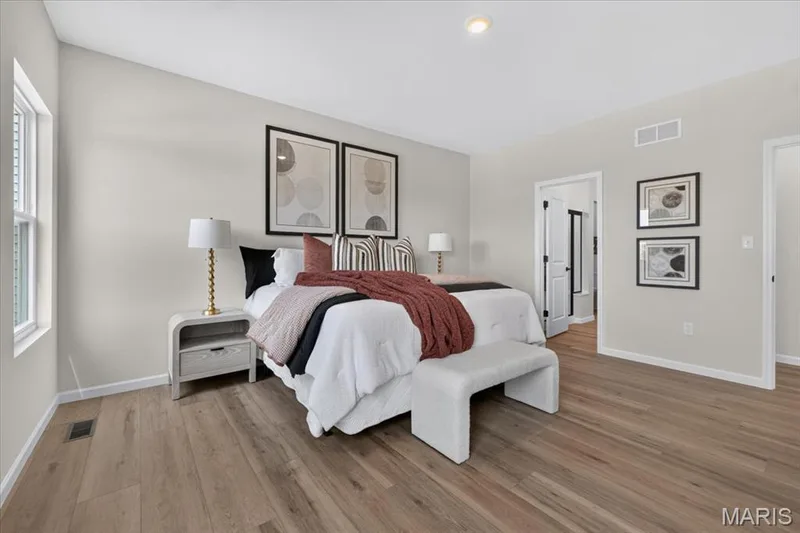 The light-filled primary bedroom provides a tranquil atmosphere with oversized windows, an open layout, and ample space for a king-size bed and additional seating. A private ensuite bath and walk-in closet complete this inviting owner's retreat. — 86 River Wind Drive, St Charles, MO 63301