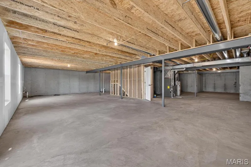 The spacious unfinished walk-out lower level is a blank canvas ready for your personal touch. With rough-in plumbing and direct outdoor access, it's ideal for future expansion and customized living. — 86 River Wind Drive, St Charles, MO 63301