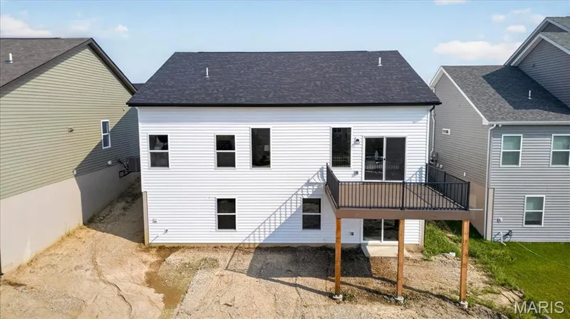 The thoughtfully designed rear elevation features a large composite deck with aluminum railing, perfect for outdoor gatherings, along with a walk-out basement that provides exceptional flexibility to create additional living space while maintaining convenient access to the backyard. — 86 River Wind Drive, St Charles, MO 63301
