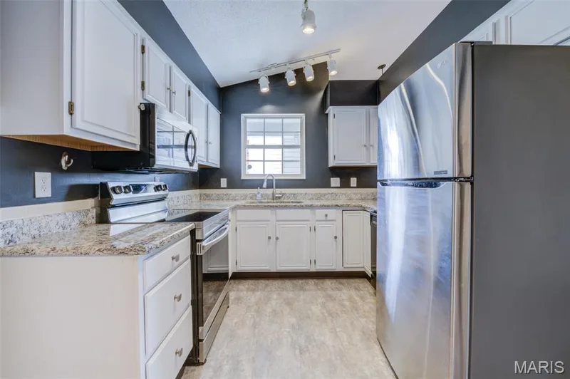 Galley kitchen with stainless-steel appliances & hard surface counter-tops. — 1647 Chapman Court, St Charles, MO 63303