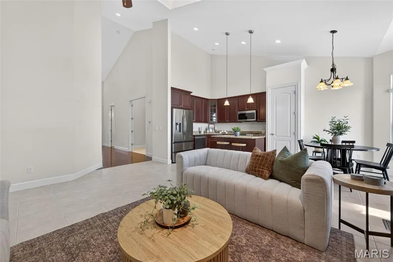 Open-concept living area featuring high vaulted ceilings, light tile flooring, and recessed lighting — 216 Woodland Place Court, St Charles, MO 63303