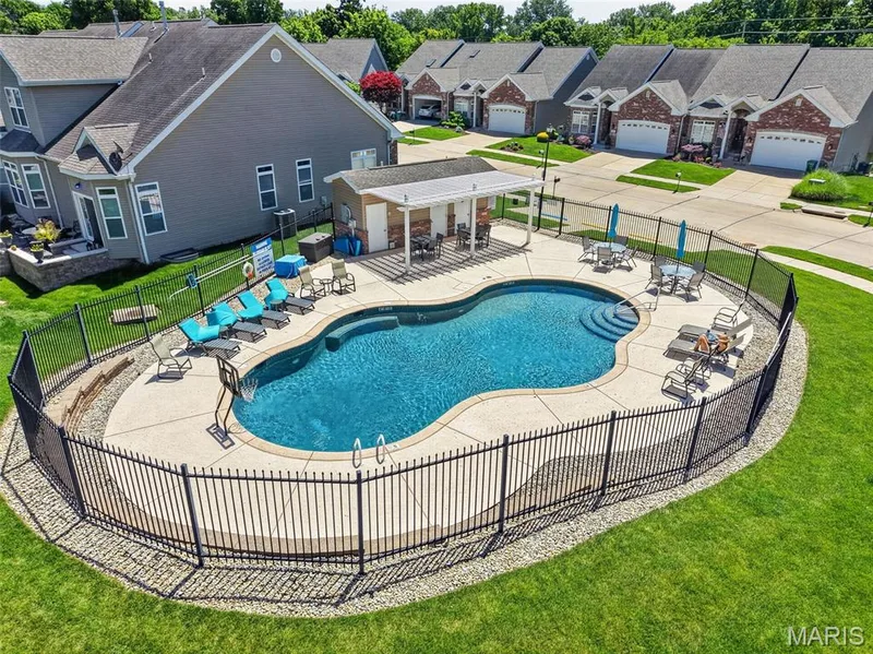 Community/Subdivision outdoor swimming pool with concrete surround and integrated steps — 216 Woodland Place Court, St Charles, MO 63303