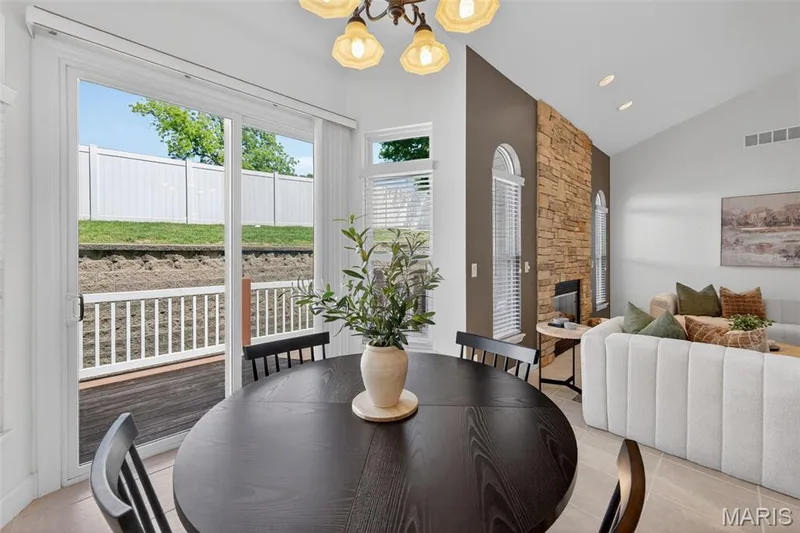 Open-concept dining area with sliding glass door providing exterior access — 216 Woodland Place Court, St Charles, MO 63303