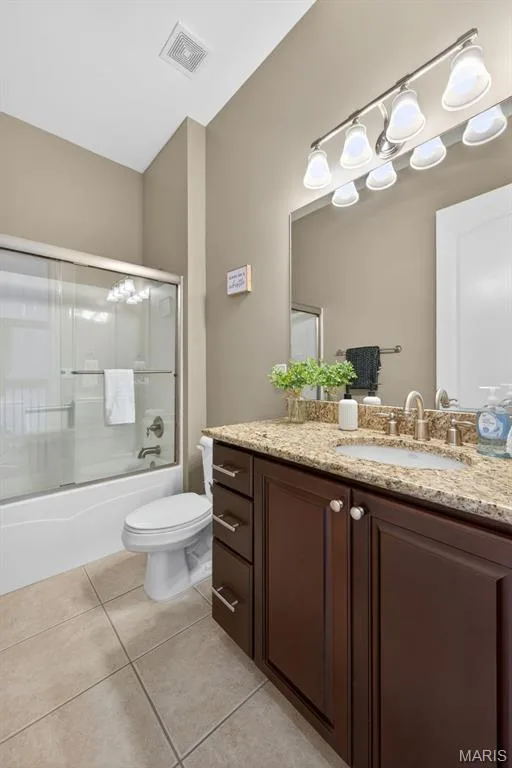 Full bathroom featuring a dark wood vanity with a granite countertop and brushed nickel hardware — 216 Woodland Place Court, St Charles, MO 63303