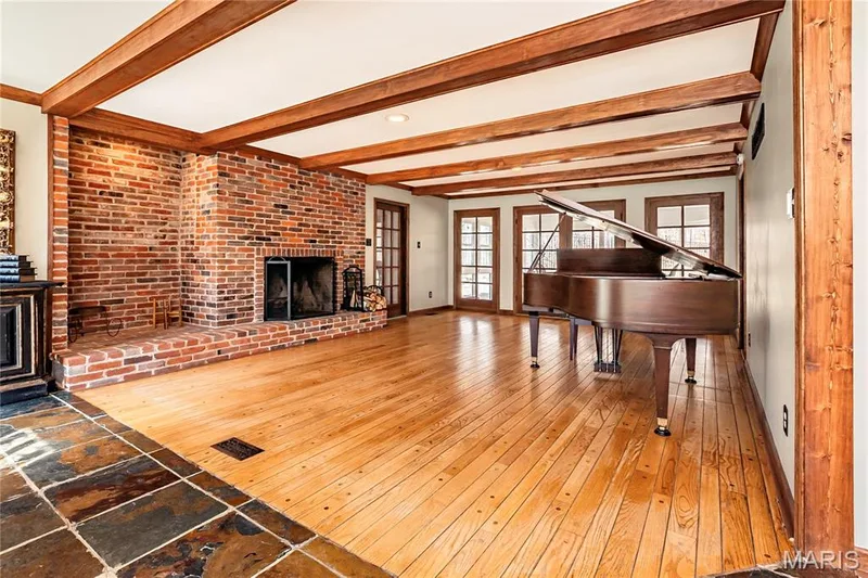 Gleaming wood floors and new Wood Beams on the ceiling. The cozy Woodburning Brick Fireplace has a new light as well. — 4600 Cliff Forest Drive, Wildwood, MO 63069