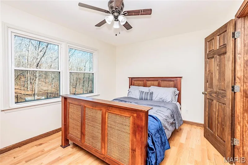 Second Bedroom Upstairs features wood flooring, large windows over looking the pool area. — 4600 Cliff Forest Drive, Wildwood, MO 63069