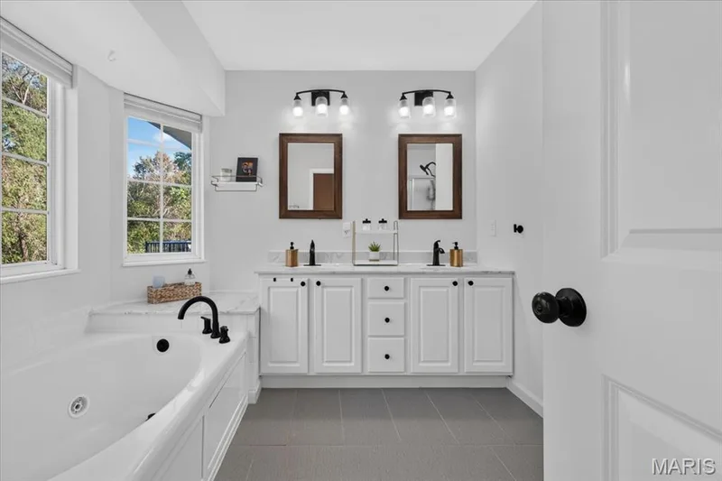 Unwind in the updated primary bath with a soaking tub, separate shower, and double vanity — 2707 Post Meadows Drive, O'Fallon, MO 63368
