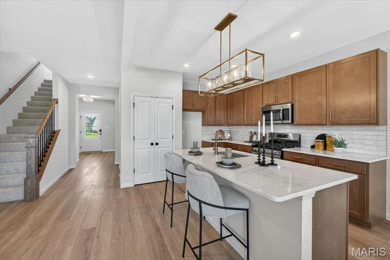 Kitchen area with custom cabinets, stainless steel gas appliances and Quartz countertops — 30 River Wind Drive, St Charles, MO 63301
