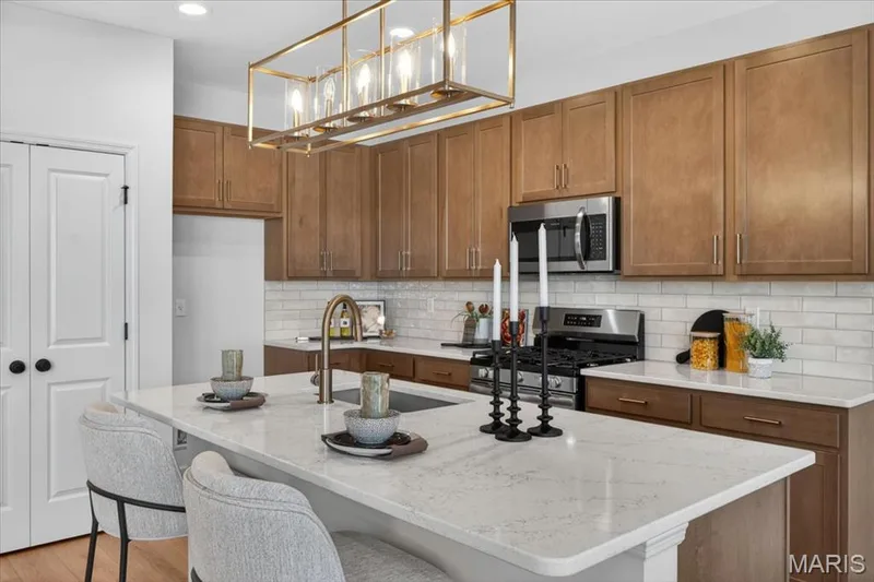Kitchen area with custom cabinets, stainless steel gas appliances and Quartz countertops — 30 River Wind Drive, St Charles, MO 63301
