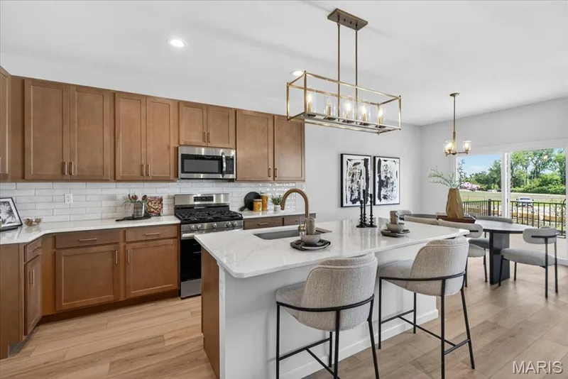 Kitchen area with custom cabinets, stainless steel gas appliances and Quartz countertops — 30 River Wind Drive, St Charles, MO 63301