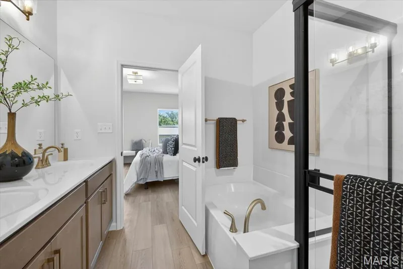 Primary bathroom with veiw of shower, tub and double bowl vanity — 30 River Wind Drive, St Charles, MO 63301