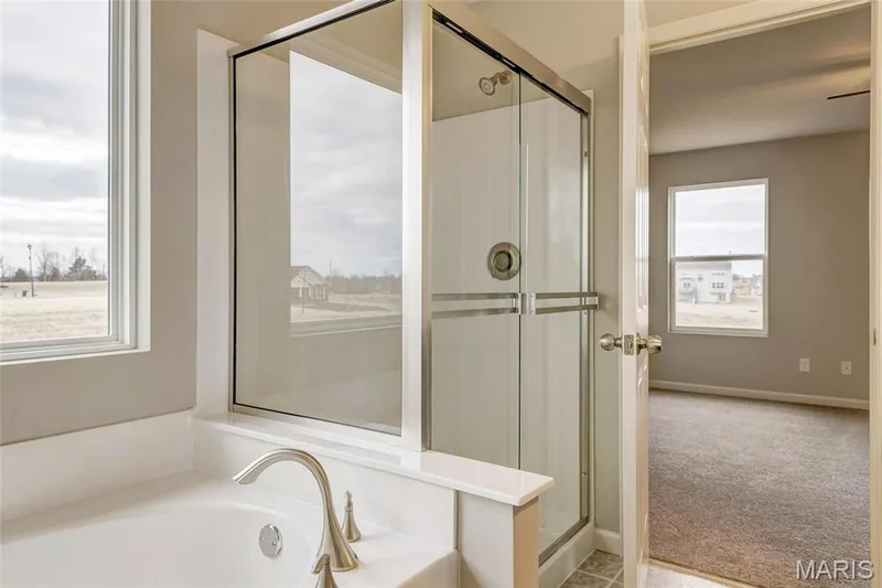 Primary bath with separate tub and walk in shower with bypass doors. — 0 Sheridan @ Harvest, O'Fallon, MO 63385
