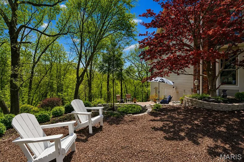 Terraced outdoor area with a lower patio, stone retaining wall, and mature trees — 1553 Ridge Road, Wildwood, MO 63021