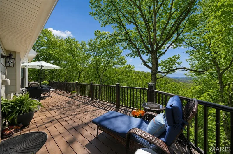 Expansive outdoor deck with wood-finish flooring, dark railing, and integrated lighting — 1553 Ridge Road, Wildwood, MO 63021