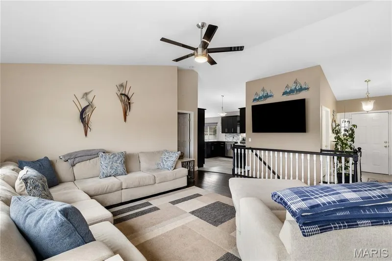 Living area with wood finished floors and a ceiling fan — 10107 Greenbriar Court, Foristell, MO 63348