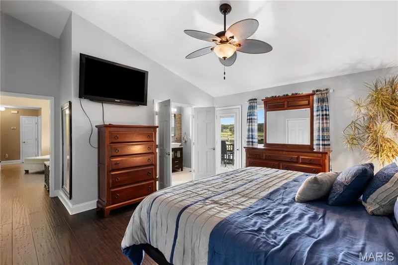 Bedroom with hardwood / wood-style flooring, a ceiling fan, access to outside, and high vaulted ceiling — 10107 Greenbriar Court, Foristell, MO 63348