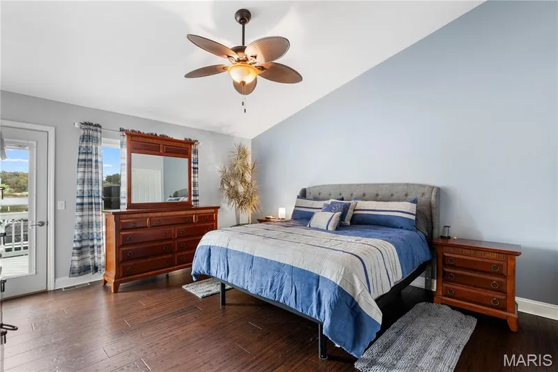 Bedroom with lofted ceiling, access to outside, dark wood-type flooring, and ceiling fan — 10107 Greenbriar Court, Foristell, MO 63348