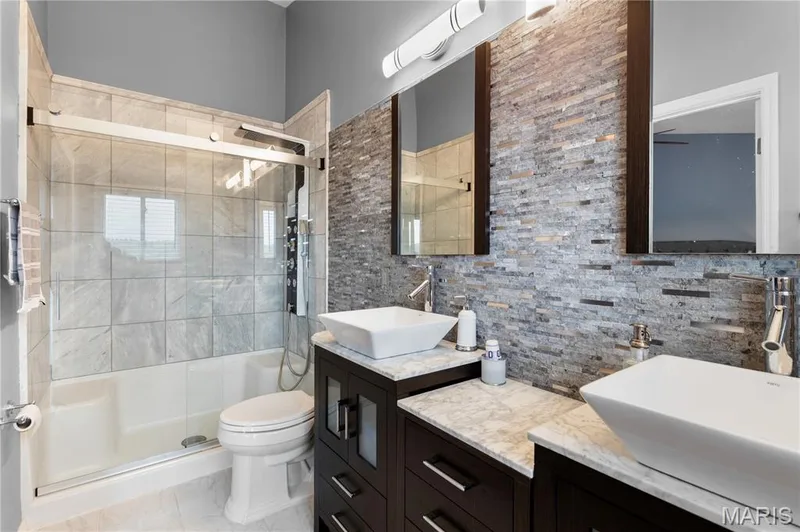 Full bath featuring vanity, a shower stall, and backsplash — 10107 Greenbriar Court, Foristell, MO 63348