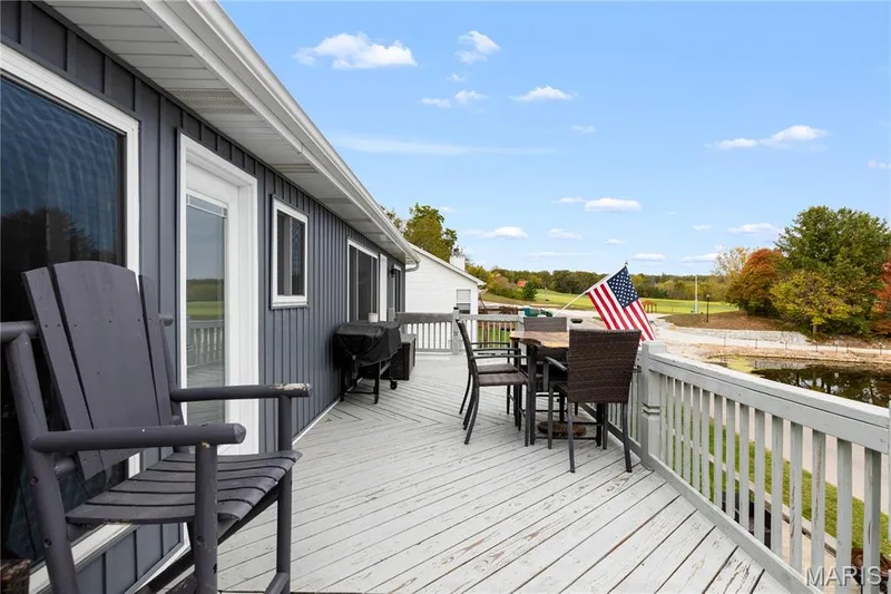 Wooden terrace featuring outdoor dining space and a grill — 10107 Greenbriar Court, Foristell, MO 63348