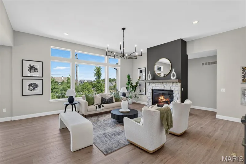 Spacious Great area featuring large windows, wood-finish flooring, a stone fireplace with a dark accent wall, and 11 FT ceilings — 126 Royal Troon Drive, Dardenne Prairie, MO 63368
