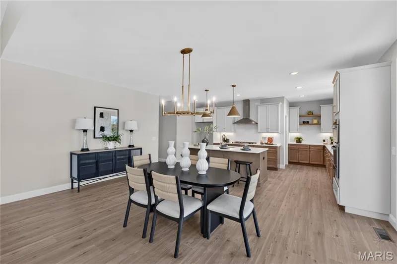 Spacious dining area with wood-finish flooring and a contemporary chandelier — 126 Royal Troon Drive, Dardenne Prairie, MO 63368