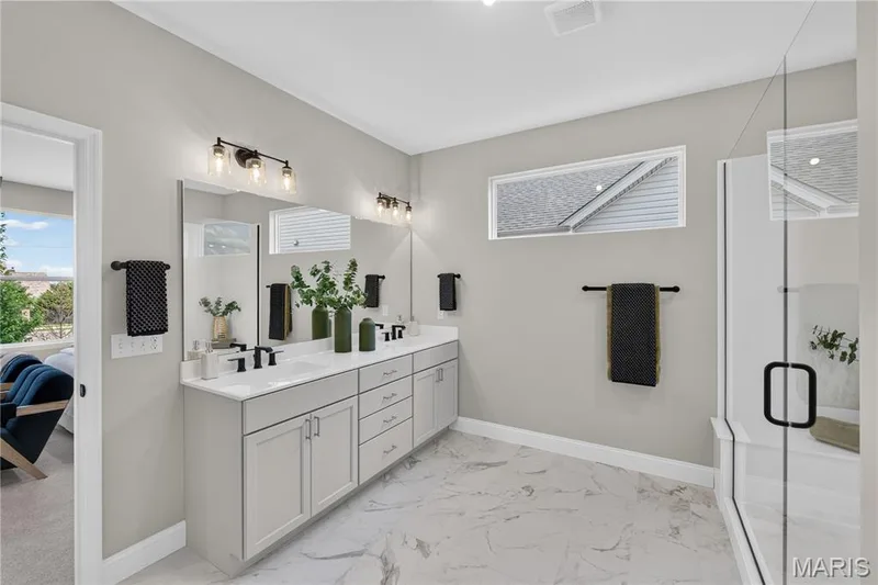 Double vanity with white cabinetry, dual sinks, and black fixtures — 126 Royal Troon Drive, Dardenne Prairie, MO 63368