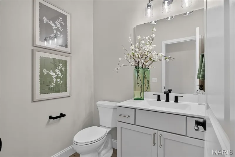 Poweder bath with white vanity with matte black hardware and a coordinating faucet — 126 Royal Troon Drive, Dardenne Prairie, MO 63368